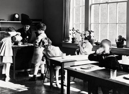Maria Montessori observing children in the Casa dei Bambini